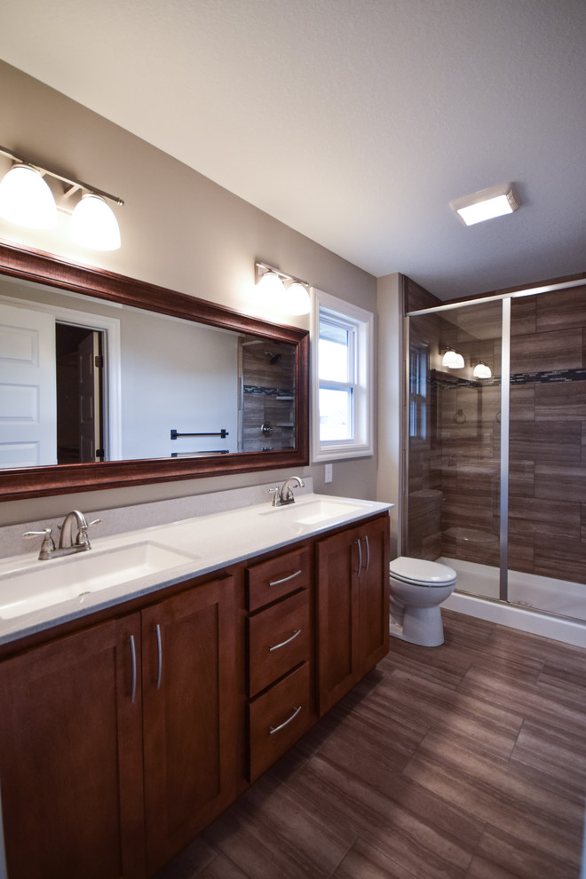 Imagen de cuarto de baño tradicional renovado con armarios estilo shaker, puertas de armario de madera oscura, ducha empotrada, baldosas y/o azulejos marrones, paredes beige y lavabo bajoencimera