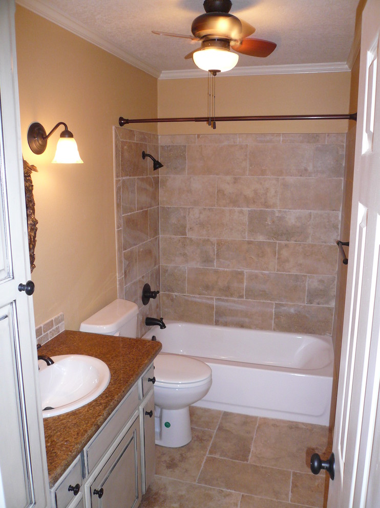 Example of a mid-sized classic kids' beige tile and stone tile travertine floor bathroom design in Other with a drop-in sink, raised-panel cabinets, distressed cabinets, granite countertops, a two-piece toilet and beige walls