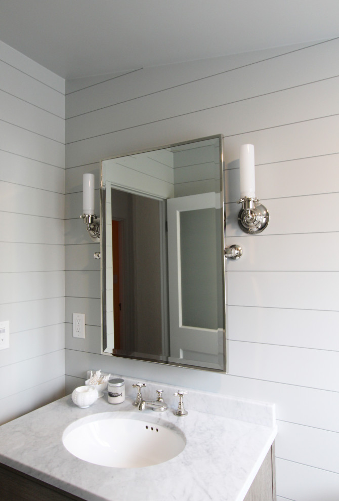 Example of a small beach style 3/4 gray tile and pebble tile marble floor, multicolored floor, single-sink and shiplap wall bathroom design in Other with furniture-like cabinets, medium tone wood cabinets, a two-piece toilet, gray walls, an undermount sink, marble countertops, a hinged shower door, white countertops and a freestanding vanity