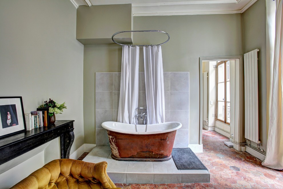 На фото: ванная комната в современном стиле с отдельно стоящей ванной, зелеными стенами и красным полом с