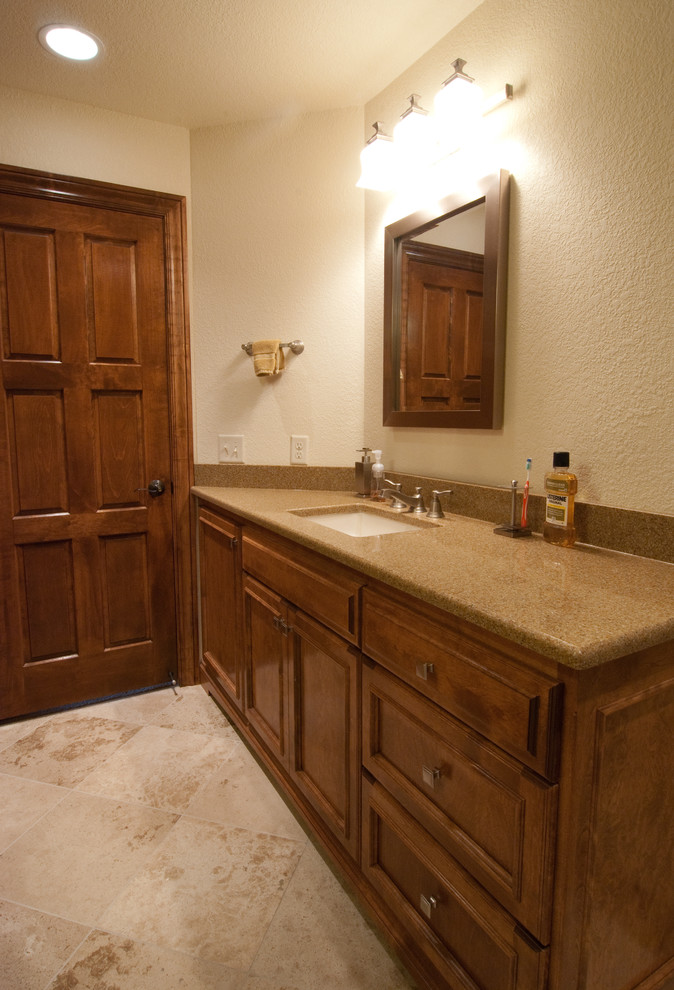 Idéer för att renovera ett mellanstort vintage en-suite badrum, med luckor med infälld panel, bruna skåp, ett undermonterat badkar, en dusch/badkar-kombination, en toalettstol med hel cisternkåpa, brun kakel, beige väggar, travertin golv, ett undermonterad handfat, granitbänkskiva, brunt golv och dusch med duschdraperi