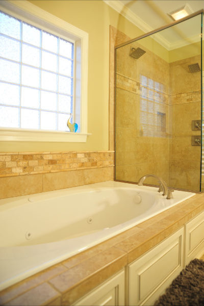 Ispirazione per una grande stanza da bagno padronale classica con vasca da incasso, doccia alcova, WC a due pezzi, pareti beige, lavabo sottopiano, top in granito e porta doccia a battente