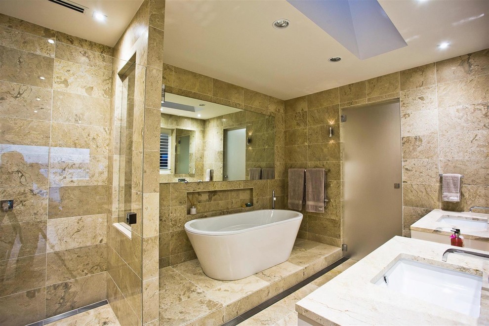На фото: главная ванная комната среднего размера в современном стиле с плоскими фасадами, белыми фасадами, отдельно стоящей ванной, душем в нише, бежевой плиткой, мраморной плиткой, мраморным полом, монолитной раковиной, столешницей из гранита, серым полом и душем с распашными дверями с