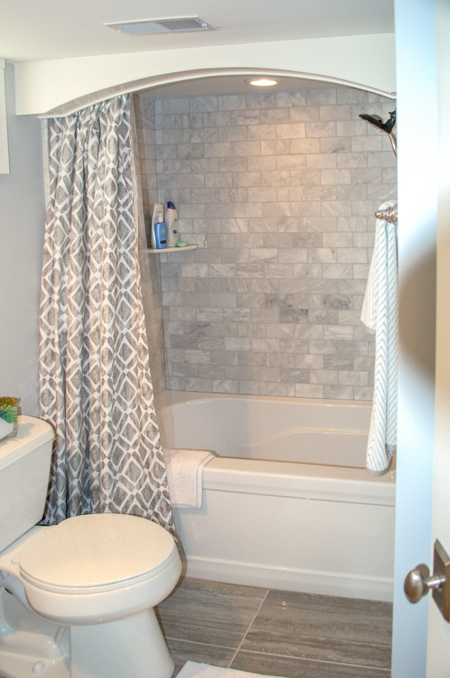 Idéer för ett litet modernt badrum för barn, med ett badkar i en alkov, en toalettstol med separat cisternkåpa, grå kakel, stenkakel, grå väggar och klinkergolv i porslin