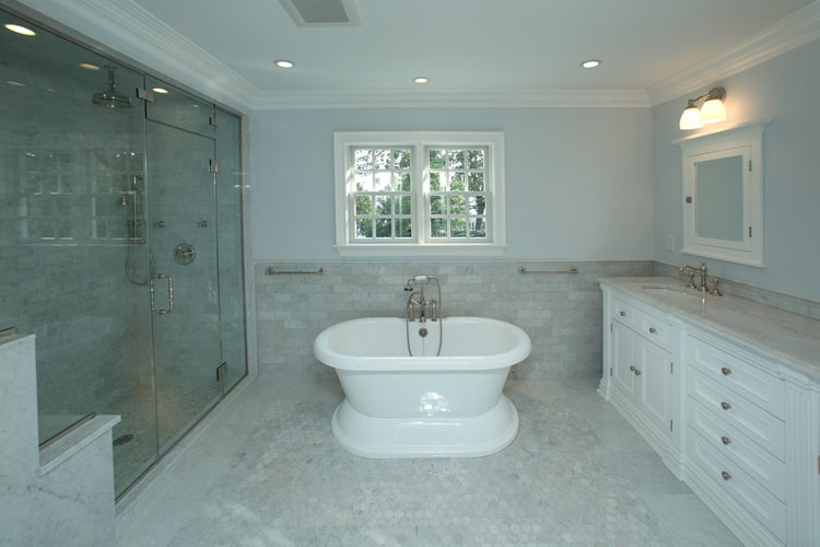 Cette photo montre une grande salle de bain principale chic avec un placard à porte shaker, des portes de placard blanches, un plan de toilette en marbre, un carrelage blanc, un carrelage métro, une baignoire indépendante, un lavabo encastré, un mur bleu et un sol en marbre.
