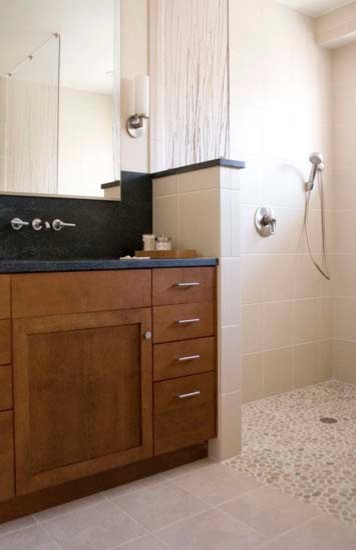 Cette image montre une salle de bain design en bois brun avec un lavabo encastré, un placard à porte plane, un plan de toilette en granite, une baignoire encastrée, une douche double, WC séparés, un carrelage beige et un carrelage de pierre.