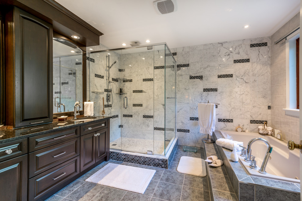 Esempio di una stanza da bagno classica con ante con bugna sagomata, ante in legno bruno, vasca da incasso, doccia ad angolo, piastrelle bianche, lavabo sottopiano, pavimento grigio, top nero e un lavabo