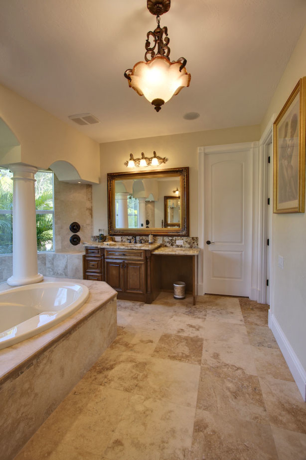 Inspiration for a huge mediterranean master beige tile and ceramic tile ceramic tile bathroom remodel in Tampa with a drop-in sink, raised-panel cabinets, dark wood cabinets, granite countertops, a one-piece toilet and beige walls