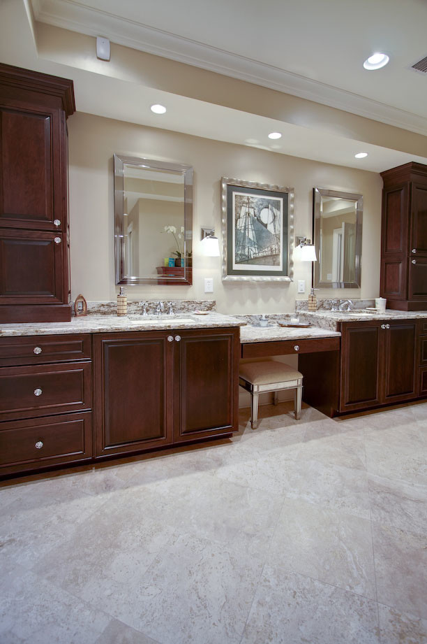 Photo of an expansive mediterranean ensuite bathroom in Tampa with a built-in sink, raised-panel cabinets, dark wood cabinets, granite worktops, a freestanding bath, an alcove shower, a one-piece toilet, beige tiles, ceramic tiles, beige walls and ceramic flooring.
