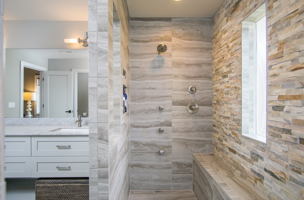 This is an example of a large modern ensuite bathroom in Chicago with recessed-panel cabinets, grey cabinets, a built-in shower, a two-piece toilet, grey tiles, ceramic tiles, grey walls, ceramic flooring, a submerged sink and marble worktops.