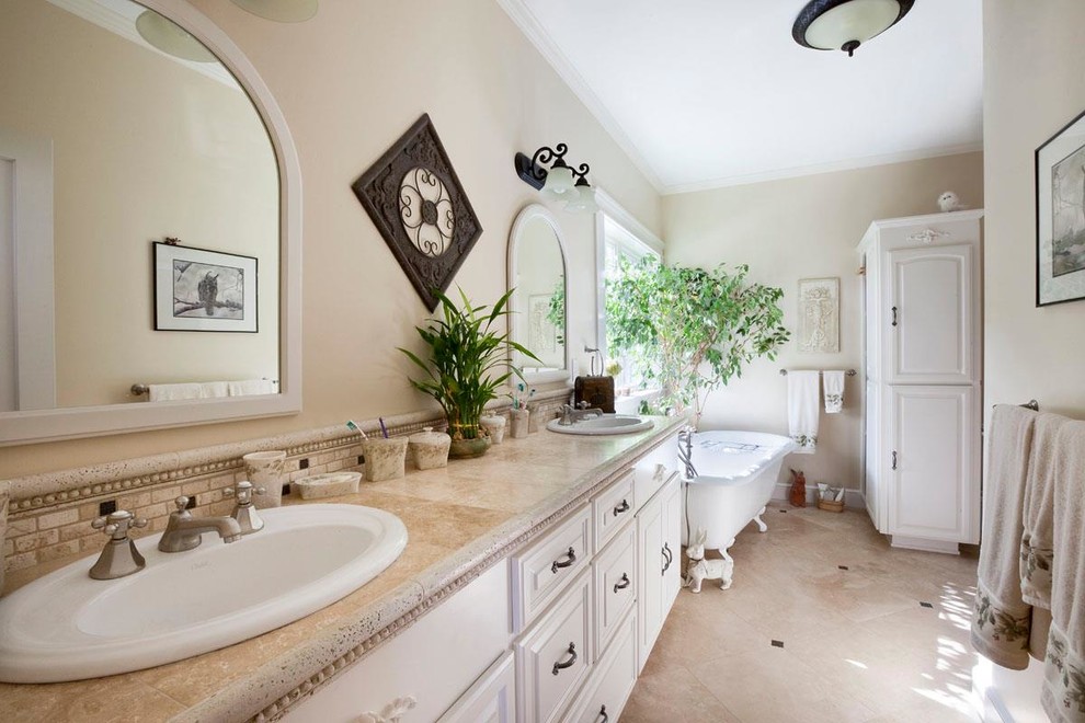 Inspiration for a large transitional master ceramic tile claw-foot bathtub remodel in Other with raised-panel cabinets, white cabinets, beige walls, a drop-in sink and granite countertops