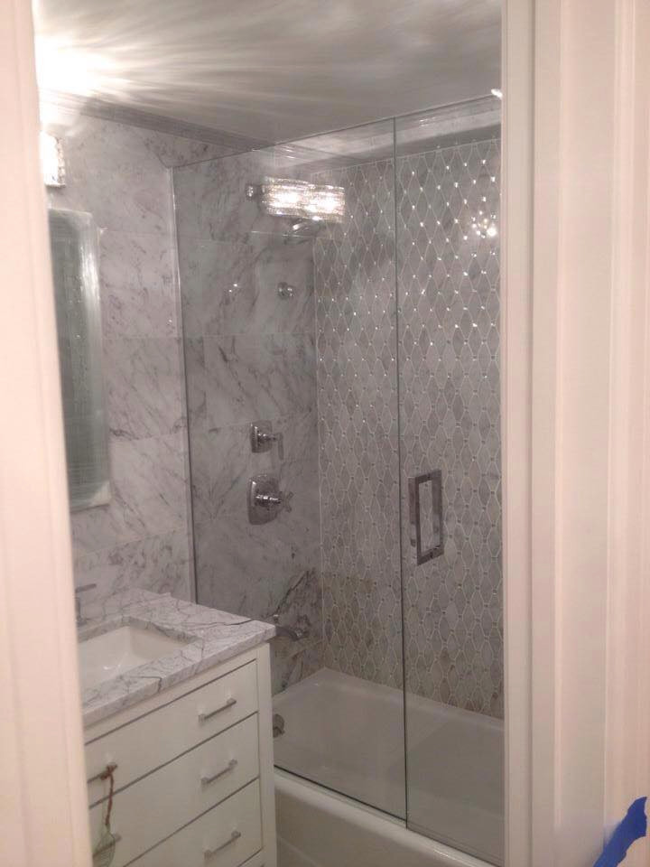 Exempel på ett litet modernt vit vitt badrum för barn, med släta luckor, vita skåp, ett platsbyggt badkar, en dusch/badkar-kombination, vit kakel, marmorkakel, vita väggar, mosaikgolv, ett undermonterad handfat, marmorbänkskiva, vitt golv och dusch med gångjärnsdörr