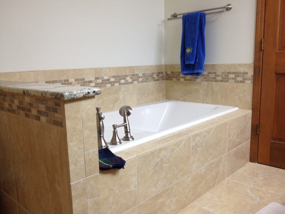 Aménagement d'une salle de bain classique avec un carrelage beige, une baignoire posée, un carrelage de pierre, un mur blanc et un sol en carrelage de porcelaine.