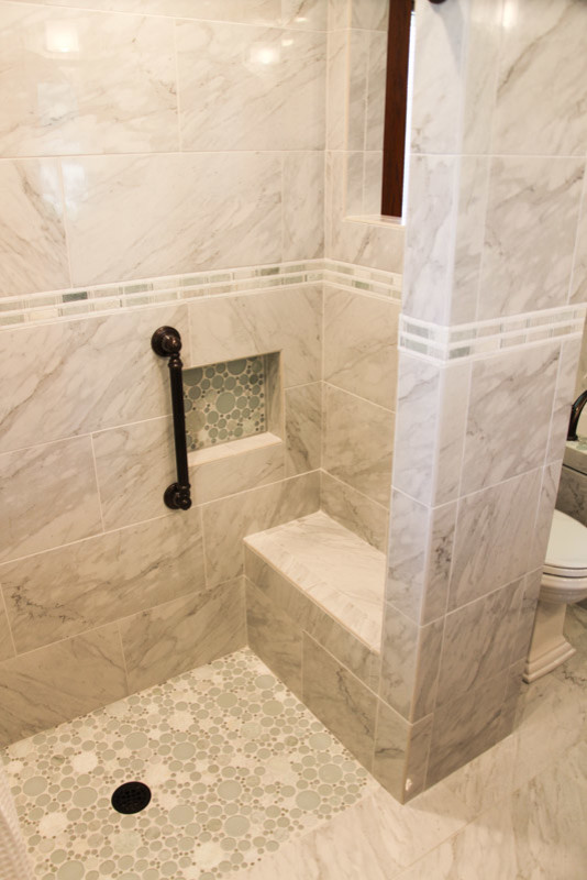 На фото: ванная комната в стиле неоклассика (современная классика) с душем в нише, серой плиткой, каменной плиткой, серыми стенами и полом из галечной плитки с