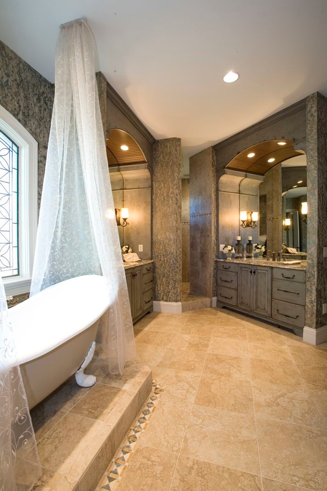 Modelo de cuarto de baño principal tradicional de tamaño medio con puertas de armario grises, encimera de granito, bañera con patas, baldosas y/o azulejos beige y baldosas y/o azulejos de cerámica