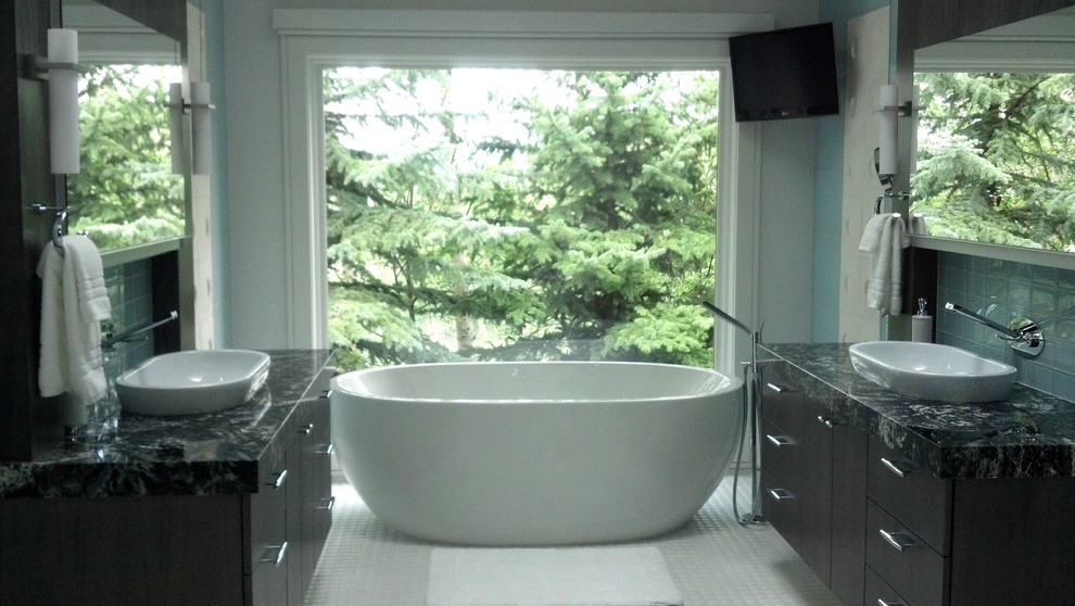 Klassisk inredning av ett stort en-suite badrum, med släta luckor, skåp i mörkt trä, ett fristående badkar, blå kakel, glaskakel, blå väggar, klinkergolv i keramik, ett fristående handfat, granitbänkskiva och vitt golv