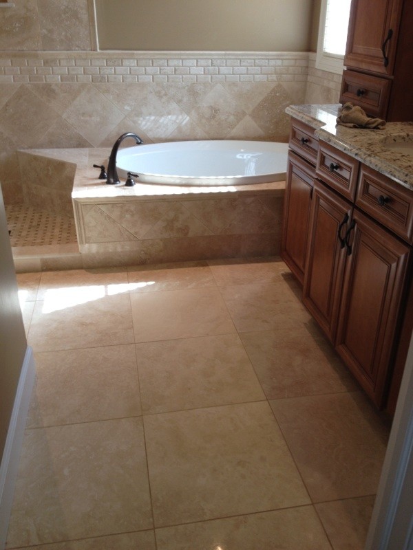 На фото: главная ванная комната в классическом стиле с накладной ванной, бежевой плиткой и каменной плиткой