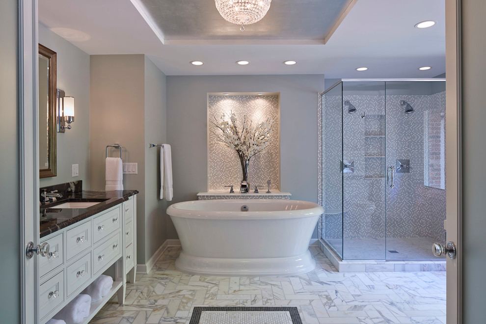 Aménagement d'une grande salle de bain principale classique avec un lavabo encastré, un placard avec porte à panneau encastré, des portes de placard blanches, un plan de toilette en marbre, une baignoire indépendante, une douche d'angle, un carrelage gris, mosaïque, un mur gris et un sol en marbre.