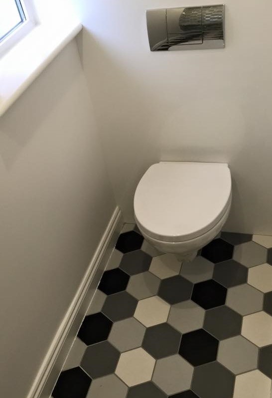 Imagen de cuarto de baño contemporáneo con sanitario de pared, baldosas y/o azulejos de porcelana, paredes blancas y suelo de baldosas de porcelana