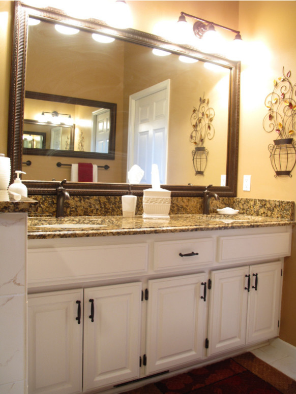 Medium sized traditional ensuite bathroom in Minneapolis with raised-panel cabinets, white cabinets, a corner shower, brown tiles, glass tiles, beige walls, a submerged sink and granite worktops.