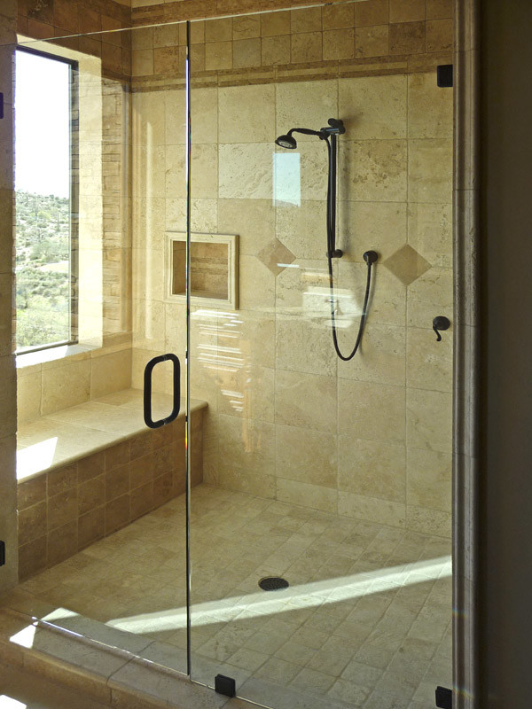 This is an example of a large traditional ensuite bathroom in Phoenix with a built-in sink, raised-panel cabinets, dark wood cabinets, granite worktops, a freestanding bath, a walk-in shower, a one-piece toilet, multi-coloured tiles, ceramic tiles, beige walls and ceramic flooring.