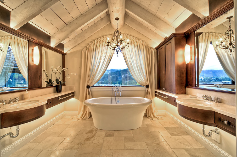 Foto di una stanza da bagno padronale mediterranea con lavabo sottopiano, ante in legno bruno, vasca freestanding, pareti beige e ante con riquadro incassato