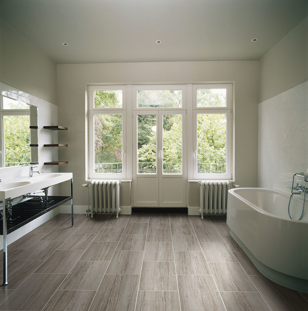 Idées déco pour une salle de bain principale moderne avec une baignoire indépendante, un mur blanc et un sol en vinyl.