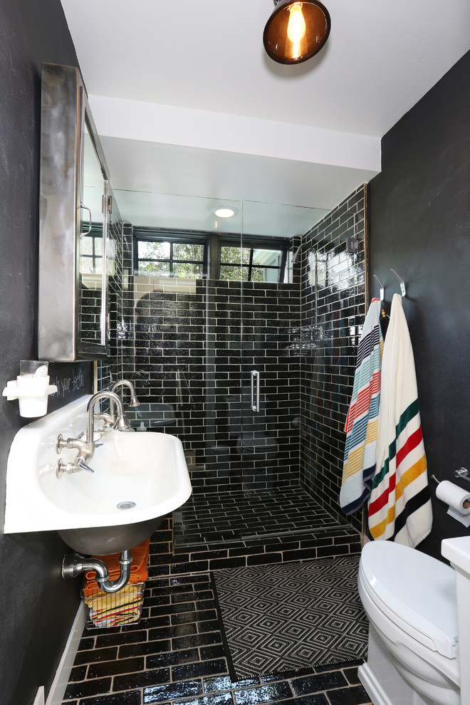Modelo de cuarto de baño contemporáneo pequeño con lavabo de seno grande, bañera exenta, ducha abierta, baldosas y/o azulejos negros, paredes negras, aseo y ducha y ducha con puerta con bisagras