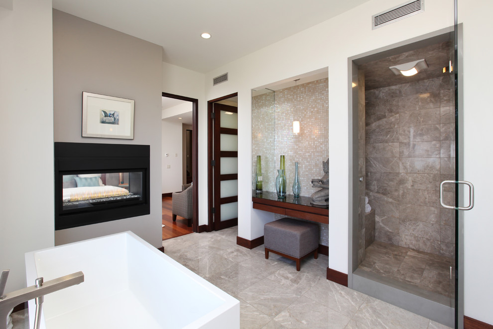 Bild på ett badrum, med ett fristående badkar och mosaik