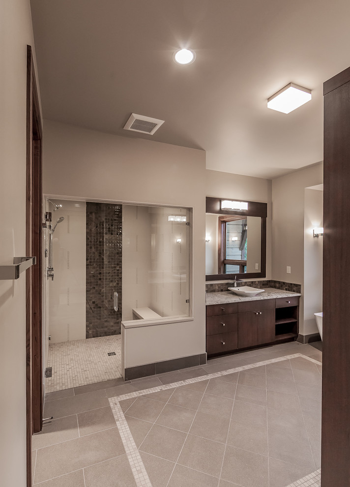 Ejemplo de cuarto de baño principal actual grande con armarios estilo shaker, puertas de armario de madera en tonos medios, ducha a ras de suelo, baldosas y/o azulejos grises, paredes beige y lavabo sobreencimera