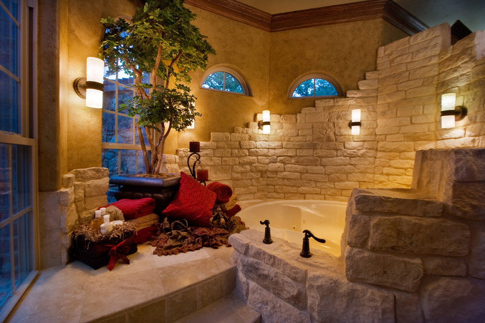 Exempel på ett stort amerikanskt en-suite badrum, med ett platsbyggt badkar, beige kakel, stenkakel, beige väggar, klinkergolv i keramik och beiget golv