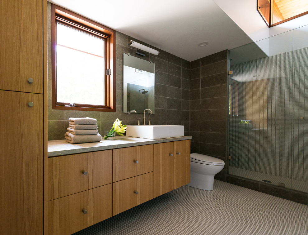 Идея дизайна: ванная комната с настольной раковиной, плоскими фасадами, душем в нише, серой плиткой и фасадами цвета дерева среднего тона