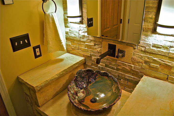 Cette image montre une petite salle d'eau traditionnelle avec une vasque, un plan de toilette en calcaire, une baignoire posée, un combiné douche/baignoire, WC à poser, un carrelage multicolore, un carrelage de pierre, un mur beige et un sol en ardoise.