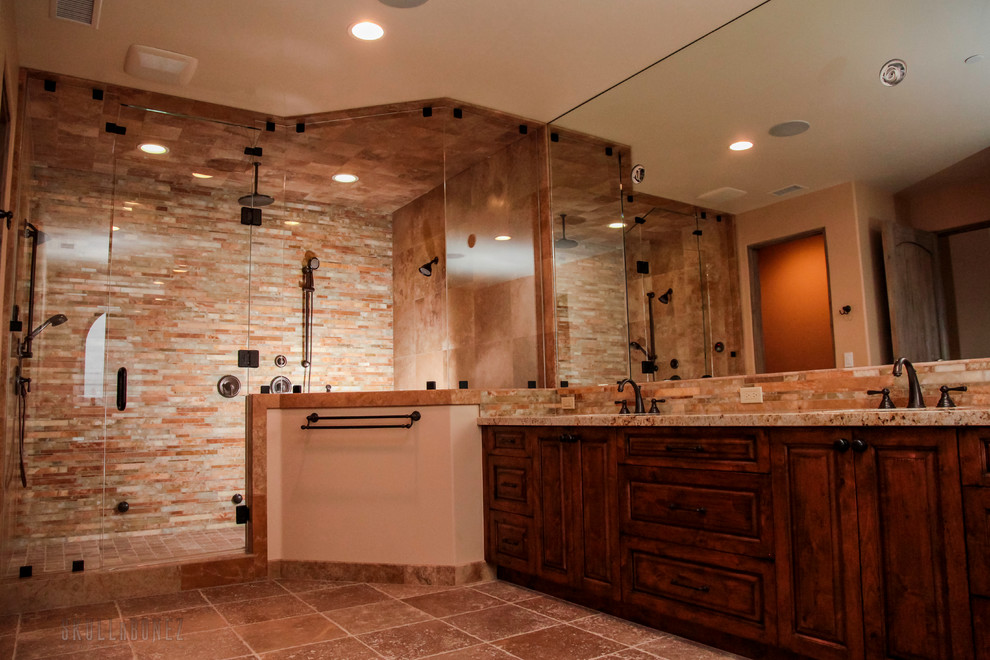 Modelo de cuarto de baño mediterráneo extra grande con armarios con paneles con relieve, puertas de armario de madera en tonos medios y encimera de granito
