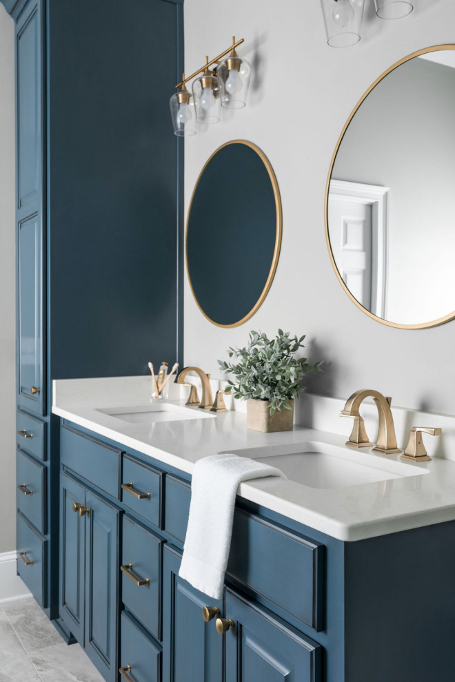 This is an example of a large classic ensuite bathroom in Atlanta with raised-panel cabinets, blue cabinets, a freestanding bath, white tiles, ceramic tiles, grey walls, porcelain flooring, a submerged sink, engineered stone worktops, grey floors, a hinged door, white worktops, a shower bench, double sinks and a built in vanity unit.