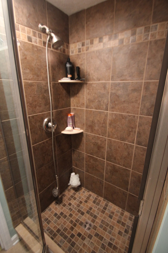 Mid-sized elegant brown tile alcove shower photo in Cleveland with glass-front cabinets, white cabinets, green walls and an undermount sink