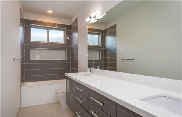 Пример оригинального дизайна: ванная комната среднего размера в стиле модернизм с плоскими фасадами, серыми фасадами, ванной в нише, душем над ванной, серой плиткой, керамогранитной плиткой, серыми стенами, полом из керамогранита, душевой кабиной, врезной раковиной, столешницей из искусственного кварца, бежевым полом и шторкой для ванной