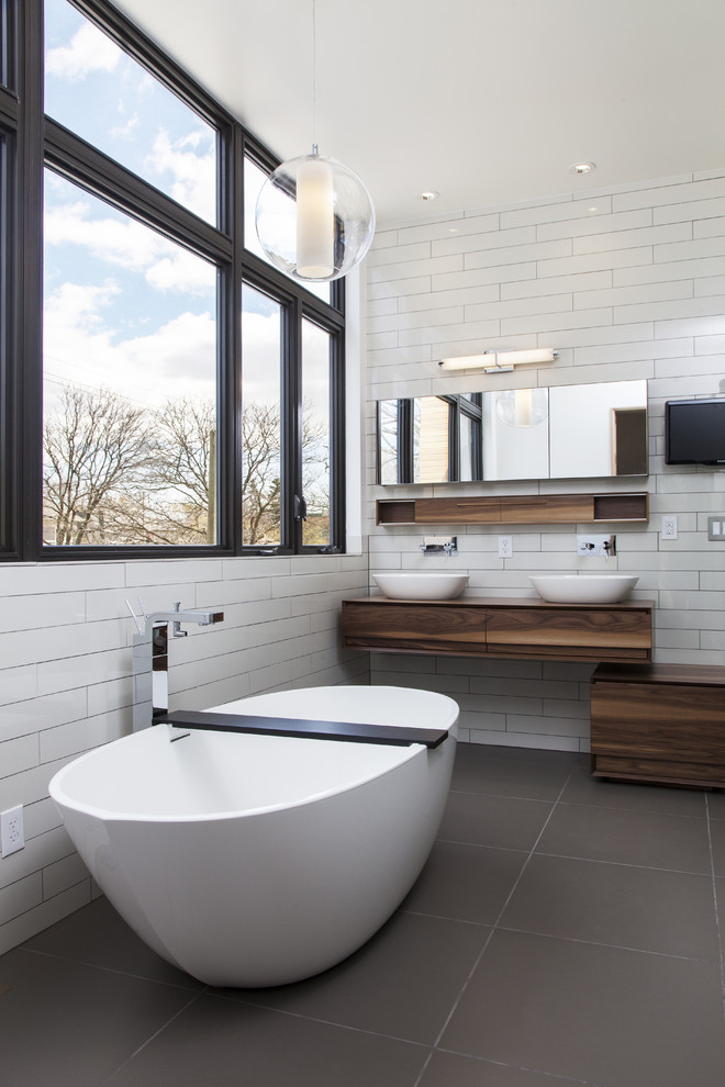 Immagine di una stanza da bagno minimal con vasca freestanding e pavimento grigio