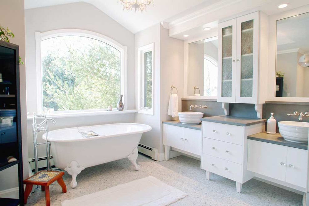 Пример оригинального дизайна: большая главная ванная комната в стиле модернизм с плоскими фасадами, белыми фасадами, ванной на ножках, серой плиткой, галечной плиткой, белыми стенами, полом из галечной плитки, настольной раковиной, столешницей из искусственного кварца, угловым душем, унитазом-моноблоком, белым полом, душем с раздвижными дверями и серой столешницей