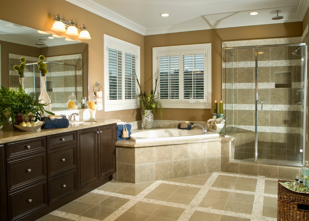 Photo of a large world-inspired ensuite bathroom in Other with recessed-panel cabinets, dark wood cabinets, a corner bath, a corner shower, brown tiles, brown walls, a submerged sink, beige floors and a hinged door.