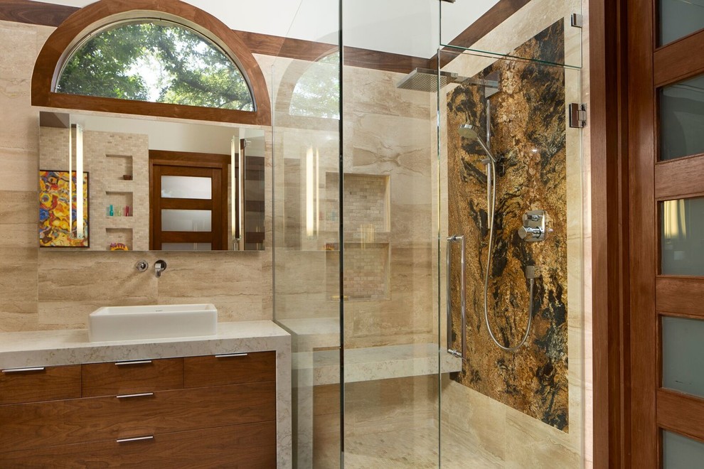 Example of a large trendy master beige tile and travertine tile mosaic tile floor and beige floor bathroom design in Dallas with flat-panel cabinets, medium tone wood cabinets, a wall-mount toilet, white walls, a vessel sink, quartzite countertops and a hinged shower door