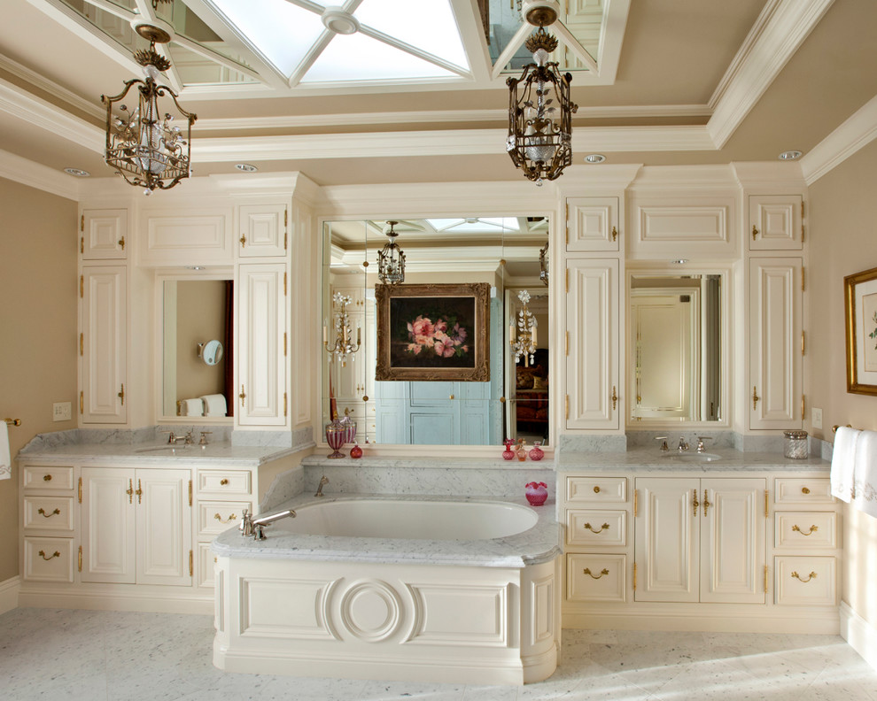 Inredning av ett klassiskt mycket stort en-suite badrum, med luckor med upphöjd panel, beige skåp, en jacuzzi, beige väggar, travertin golv, ett undermonterad handfat och granitbänkskiva