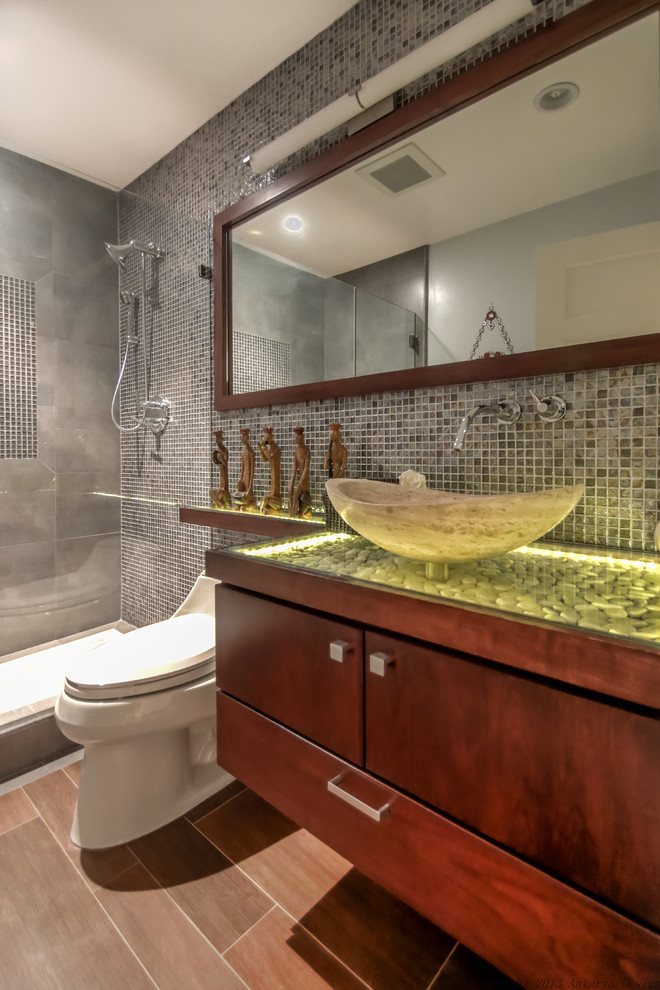 Medium sized contemporary shower room bathroom in San Francisco with a vessel sink, flat-panel cabinets, dark wood cabinets, an alcove shower, grey tiles, mosaic tiles, a one-piece toilet, medium hardwood flooring, onyx worktops, brown floors, a hinged door and yellow worktops.