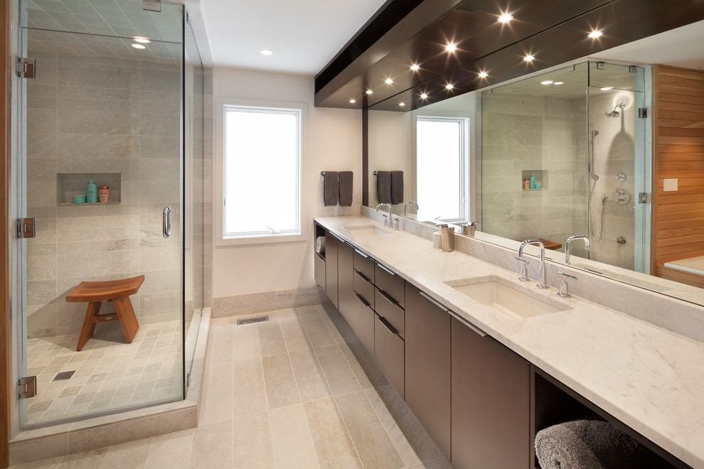 Cette photo montre une salle de bain tendance en bois foncé avec un placard à porte plane, une douche d'angle, un carrelage gris, un mur blanc, un lavabo encastré, un sol gris, une cabine de douche à porte battante et un plan de toilette blanc.