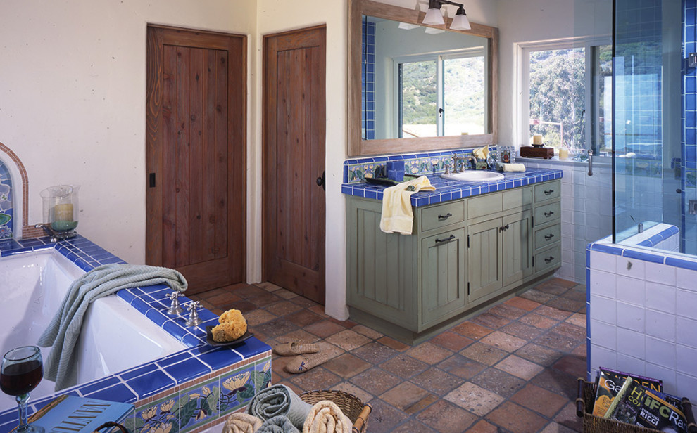 Exempel på ett stort medelhavsstil blå blått en-suite badrum, med skåp i shakerstil, skåp i slitet trä, ett undermonterat badkar, en öppen dusch, vit kakel, keramikplattor, vita väggar, klinkergolv i porslin, ett nedsänkt handfat, kaklad bänkskiva, flerfärgat golv och dusch med gångjärnsdörr