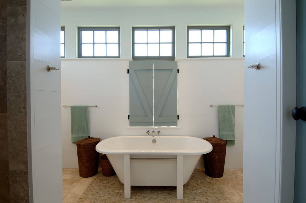 Inspiration pour une grande salle de bain rustique avec une baignoire indépendante, un carrelage beige, une plaque de galets, un mur blanc, un sol en galet, un placard à porte shaker, des portes de placard blanches, un lavabo encastré et un plan de toilette en marbre.