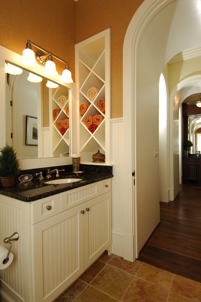 Klassisk inredning av ett mellanstort badrum, med luckor med lamellpanel, vita skåp, bruna väggar, kalkstensgolv och ett undermonterad handfat