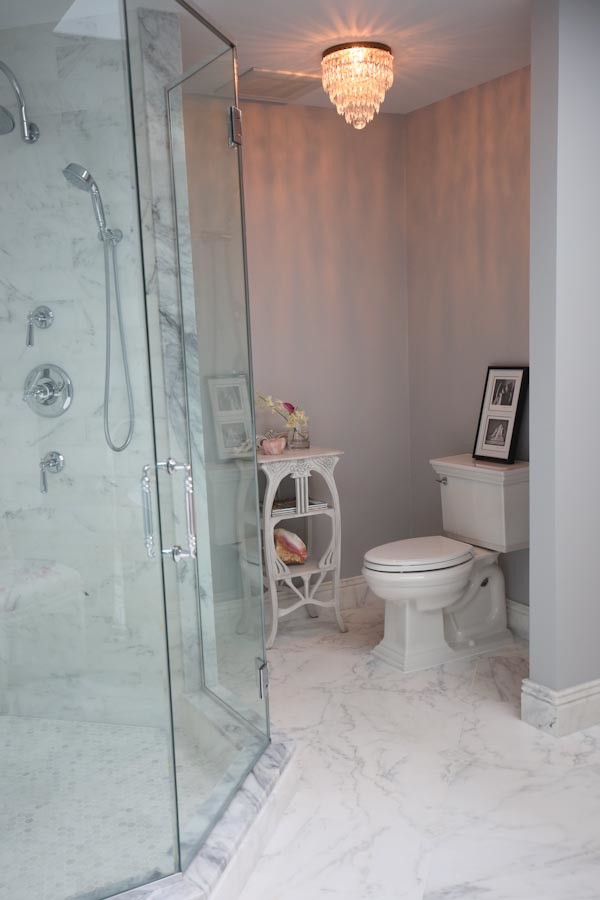 Aménagement d'une grande salle de bain principale moderne avec un placard à porte affleurante, des portes de placard blanches, une baignoire indépendante, une douche ouverte, WC séparés, un carrelage blanc, un carrelage de pierre, un mur gris, un sol en marbre, un lavabo encastré et un plan de toilette en quartz.
