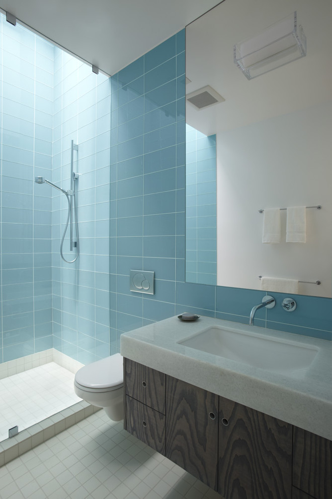Пример оригинального дизайна: ванная комната в современном стиле с инсталляцией, синей плиткой и стеклянной плиткой