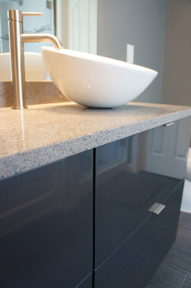 Modern ensuite bathroom in Raleigh with a vessel sink, flat-panel cabinets, grey cabinets, engineered stone worktops, grey tiles, ceramic tiles, grey walls and ceramic flooring.